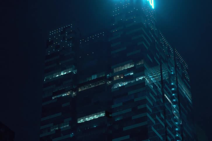 Looking up at lights turning off in an office building at night