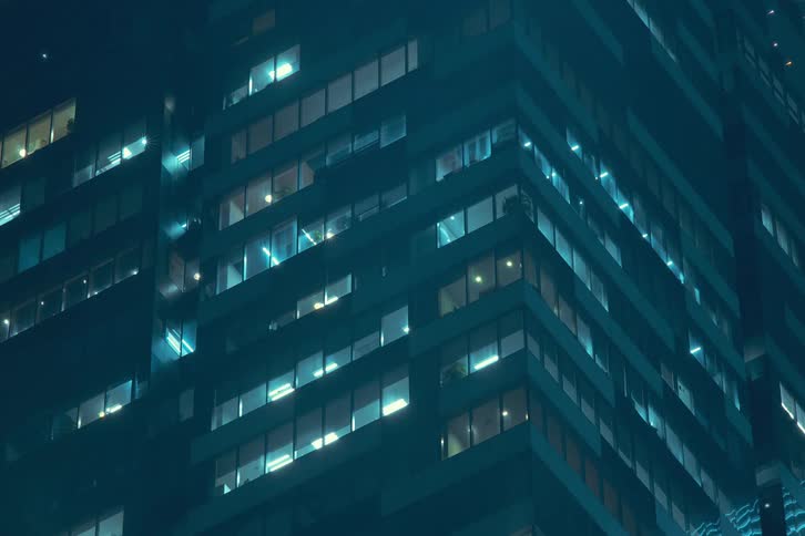 Looking up at the lights flashing then turning off in the office building windows