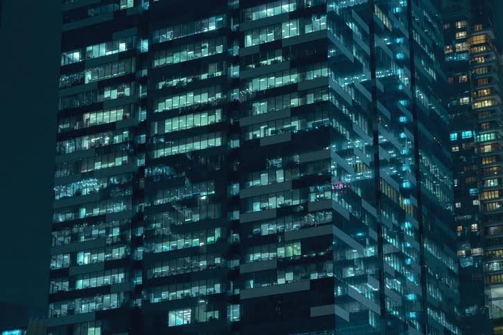 A clip of a building revealing lights turning on at night