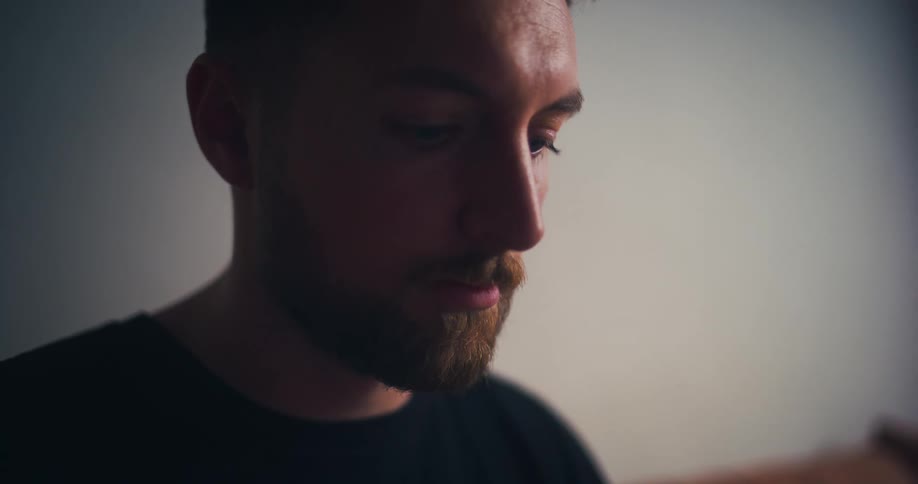 Closeup of a young man intensely focused on a task in a room