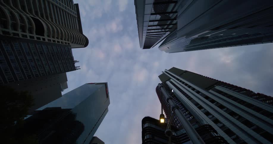 Upward view of modern buildings against a cloudy sky