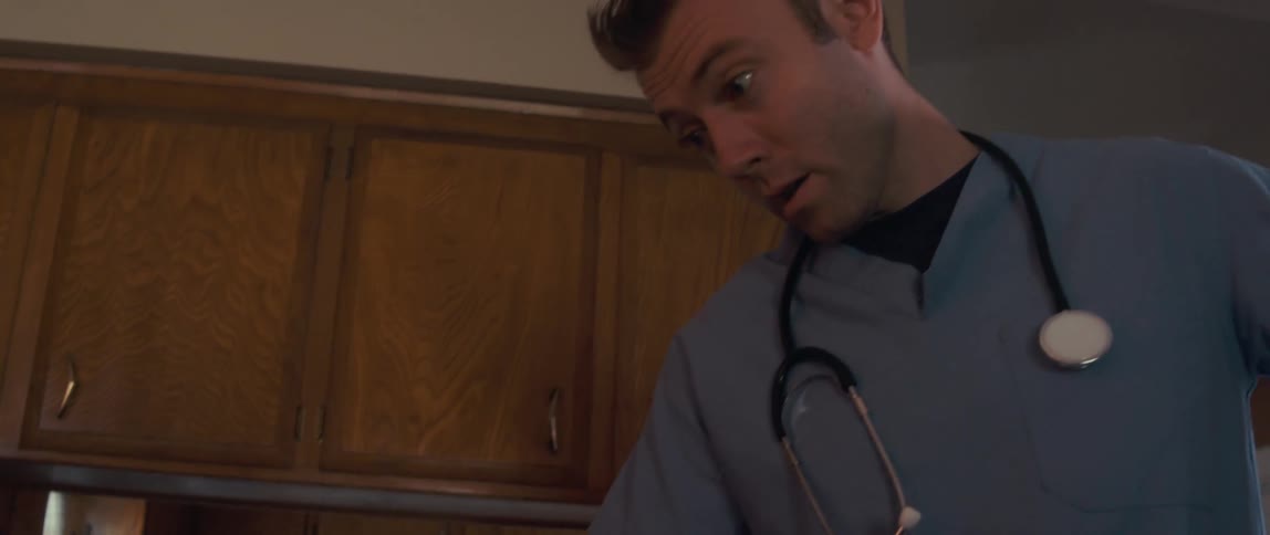 A male nurse cares for an elderly man in a cozy woodpaneled room at home