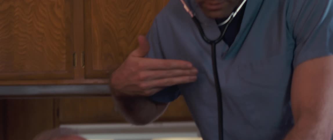 Nurse checking the heartbeat and breathing of an elderly patient