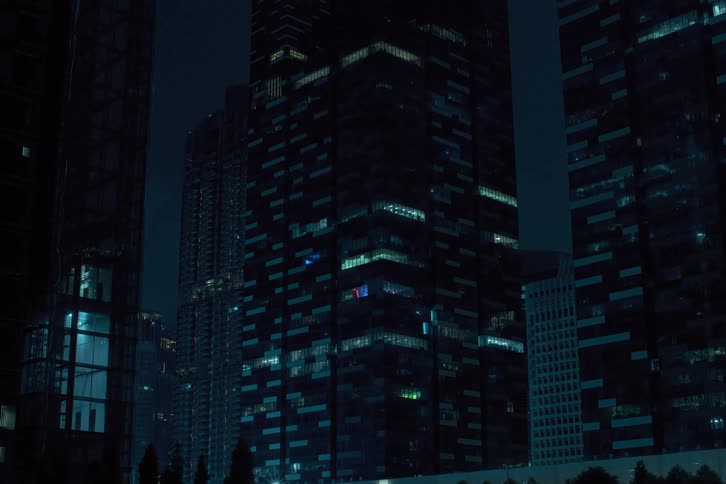 Panorama of modern buildings in a metropolis with the lights going out and turning off one by one at night