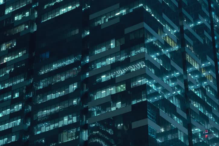 Lights of a modern building starting to turn on at night