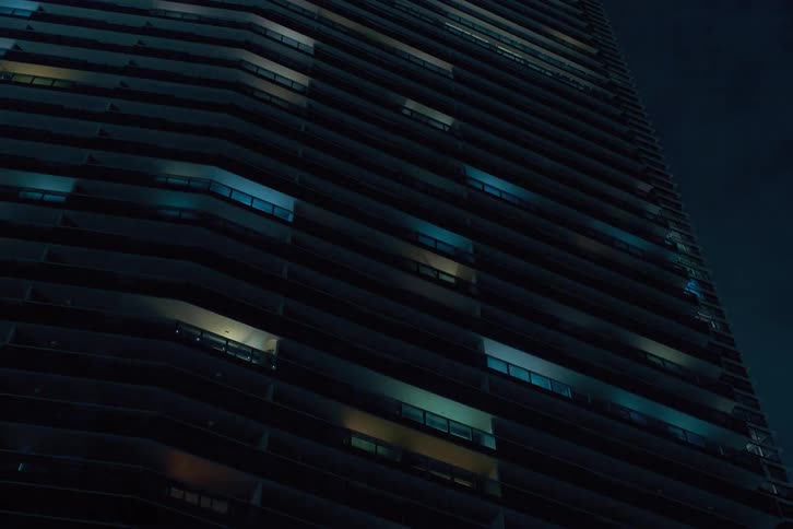 Upward view of lights blinking and flickering on a building in a city at night