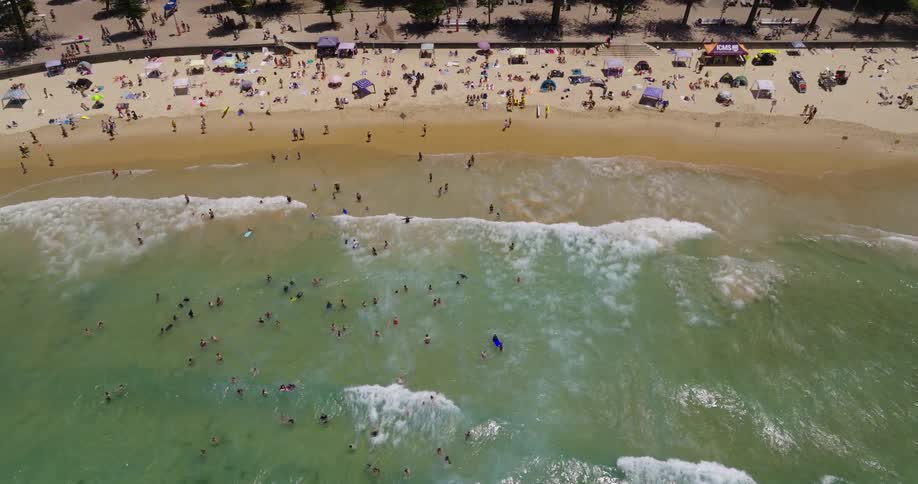 Aerial view of a crowd of sunbathers enjoying summer on the beach