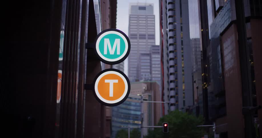 A sign with single letters is on the doorway of the building
