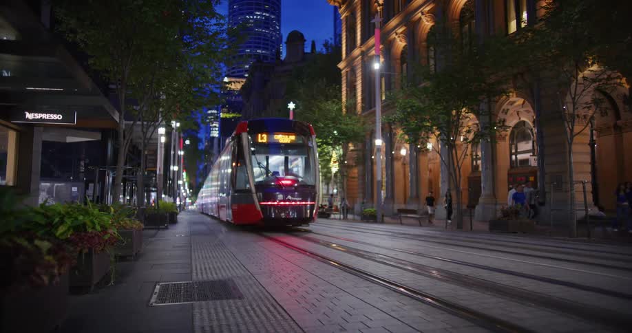 A trolley moves past the buildings in the city