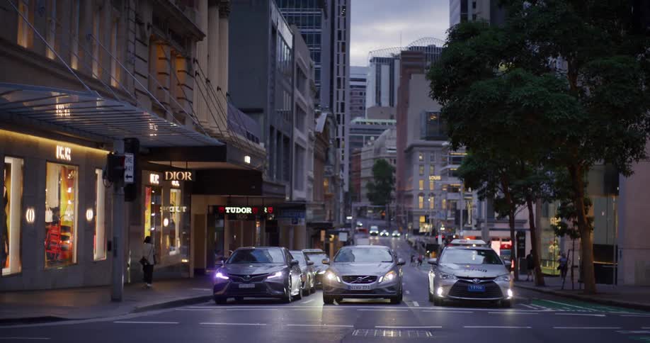 Vehicles stopped at a traffic light on an urban road in a metropolis at dusk