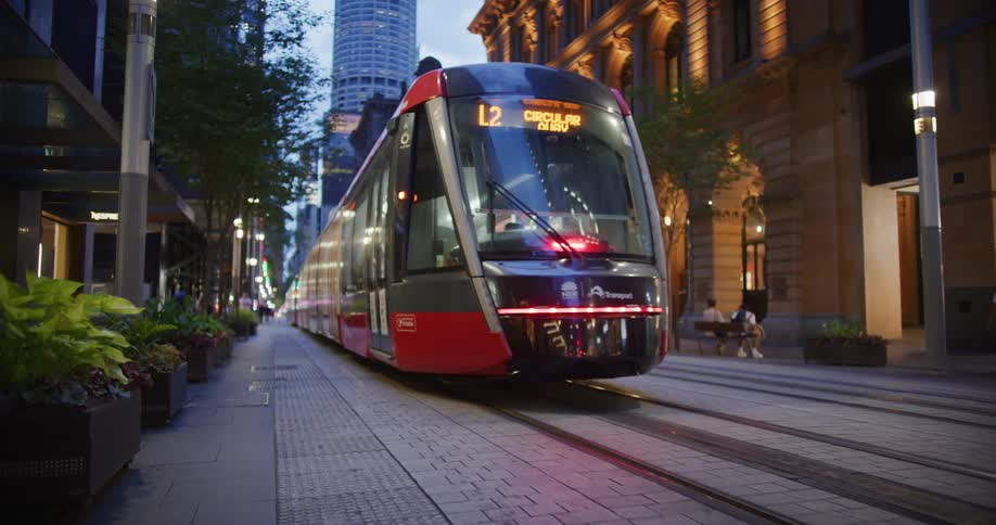 A public train moves on tracks through a city center