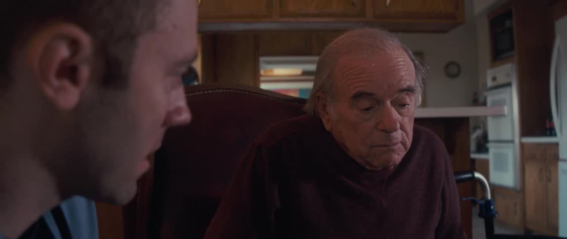 A patient points and talks with his doctor at home