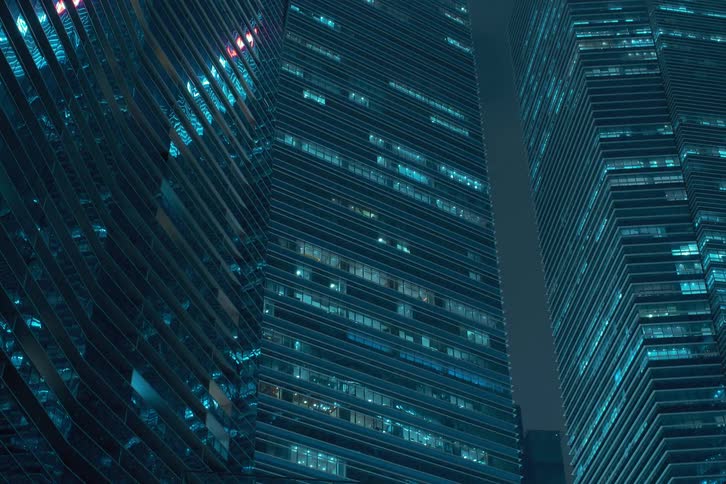 Towers of buildings with lights blinking rapidly at night