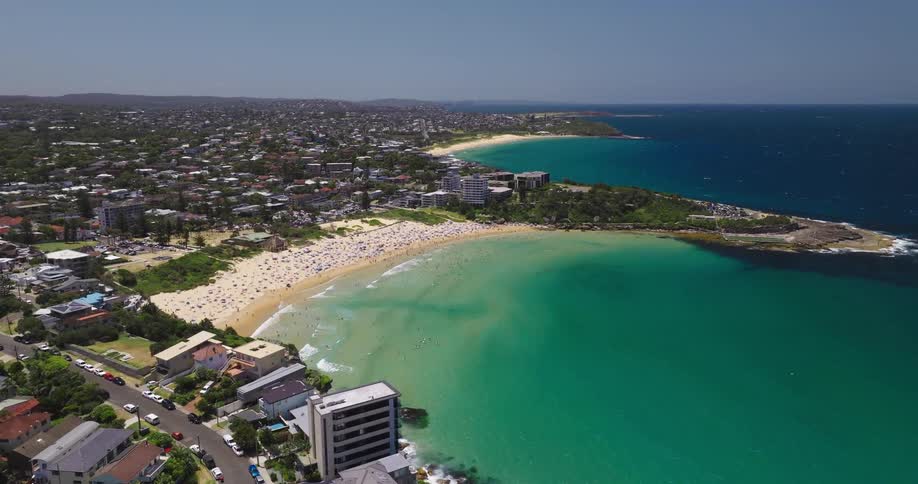 The beach is full of people on a sunny day
