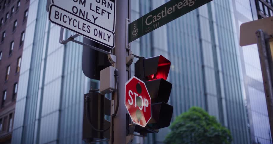 A stop sign is next to the traffic light in the city