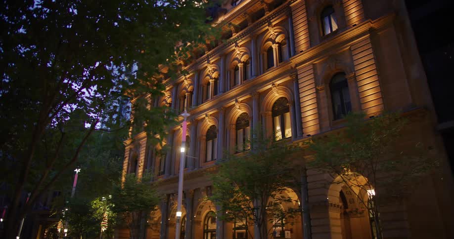 The illuminated facade of a grand historic building with ornate architectural details
