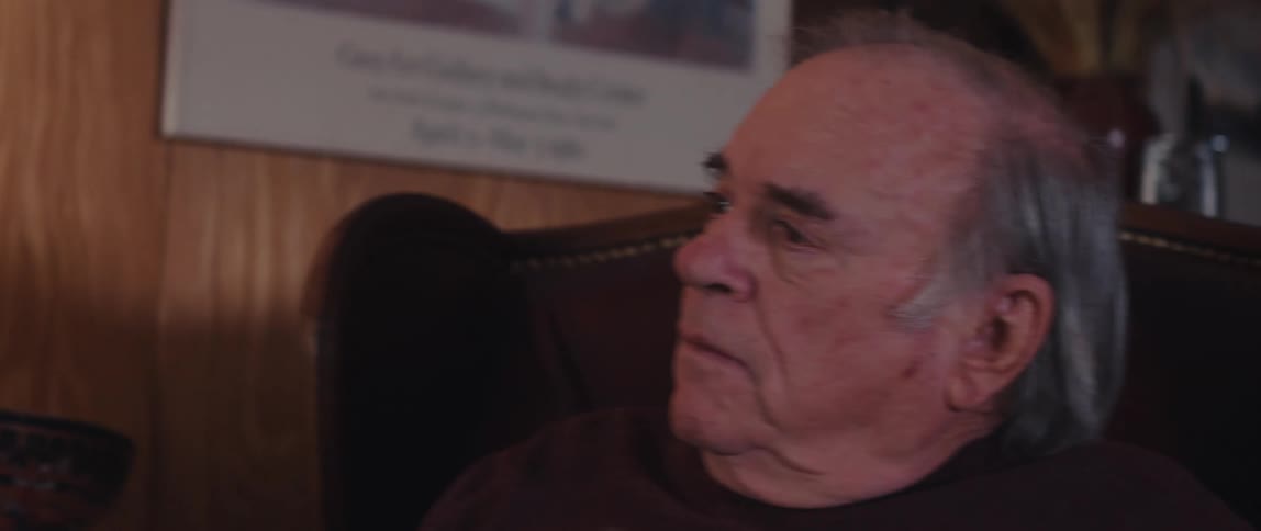 Nurse talking to an elderly man sitting next to him