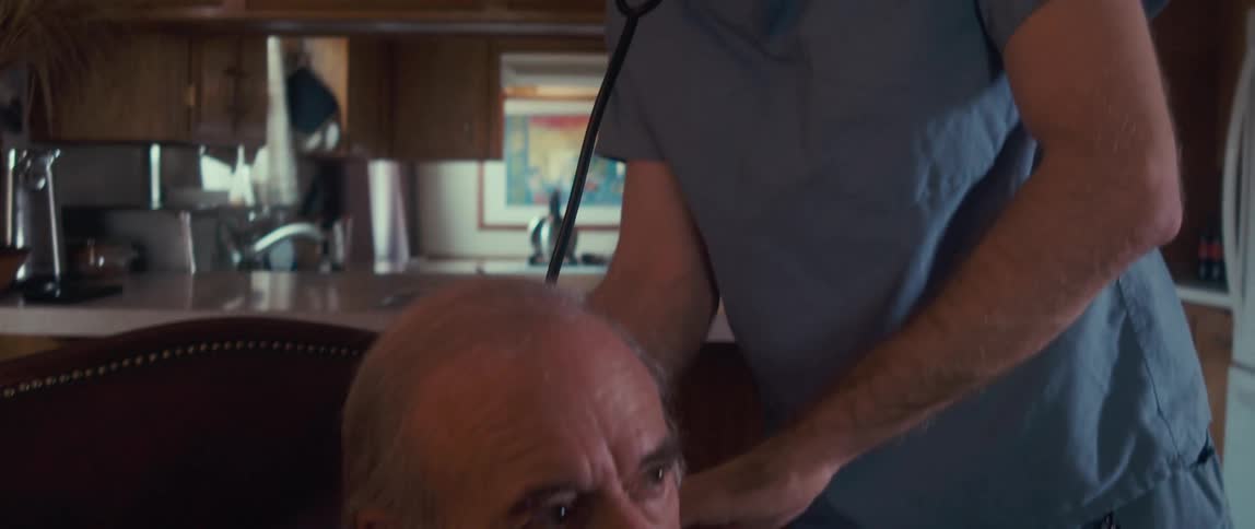 A health care professional is using a stethoscope on the mans back