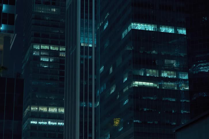A night clip of high rise buildings in the metropolis shows the window lights turning off together