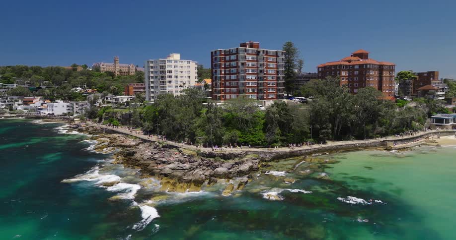 Aerial view of an urban city on the edge of a beach with greenish water