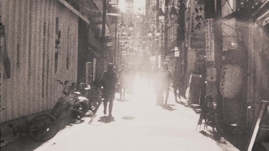 Pedestrians walking in an alley of asian shops