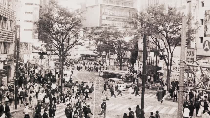 Crowds of pedestrians cross streets at downtown crosswalks during the day