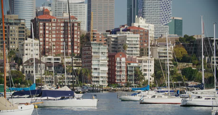 Landscape of boats and yachts floating on the water with a metropolis in the background