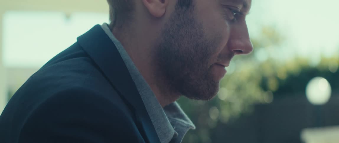 Man in blazer typing on a laptop