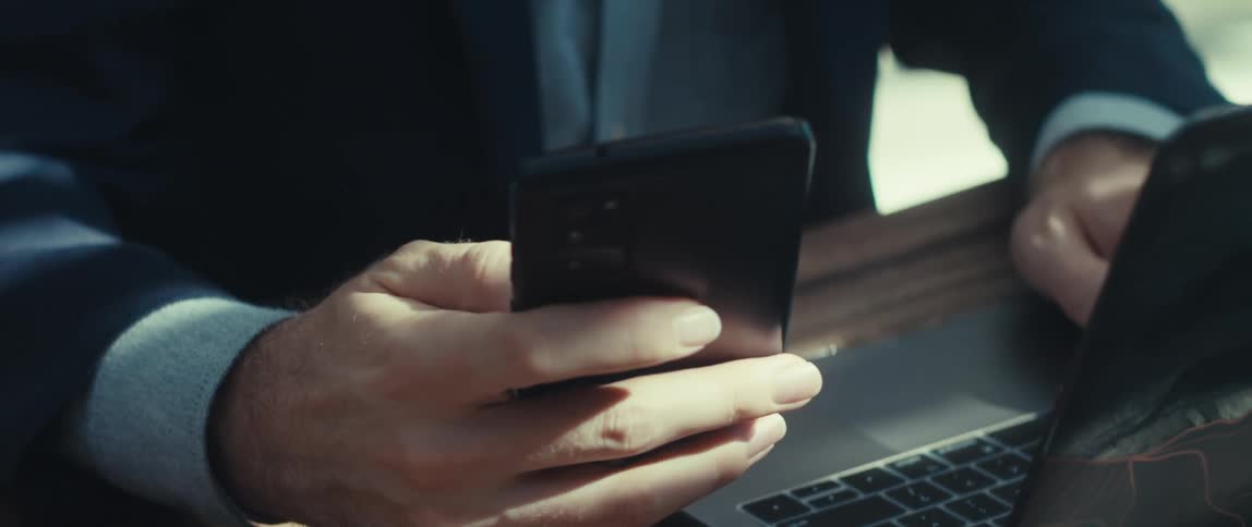 Blonde man picking up and interacting with his cell phone