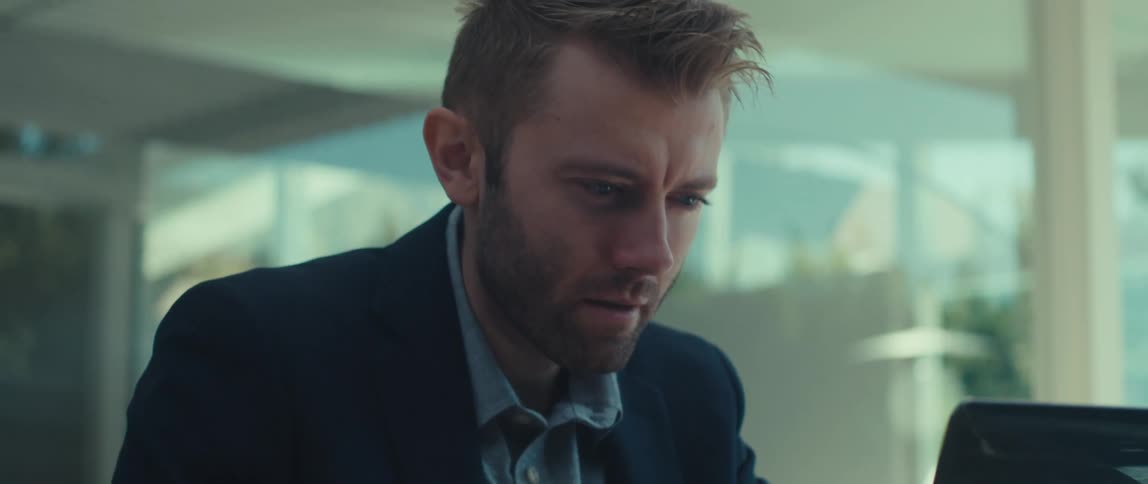 Portrait of a blond man with a beard interacting with a laptop