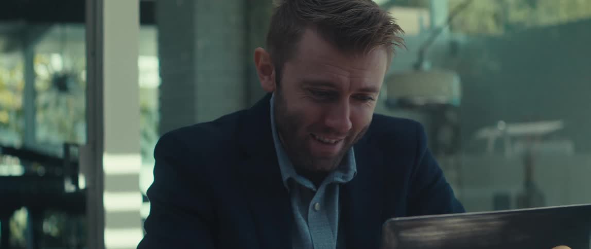 Man sitting talking in front of a laptop and making body gestures