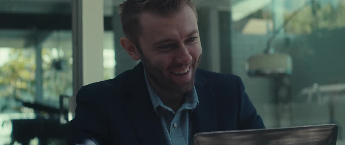 Cheerful man in a virtual meeting on laptop