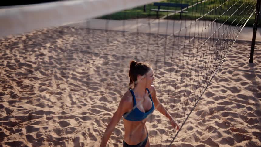 A woman jumps and hits the ball over the net
