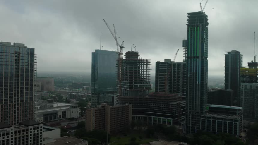 Aerial panorama of skyscrapers in a metropolis and buildings under construction on a cloudy day