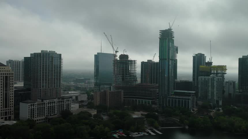 Cityscape with multiple high rise buildings under construction with cranes atop the buildings