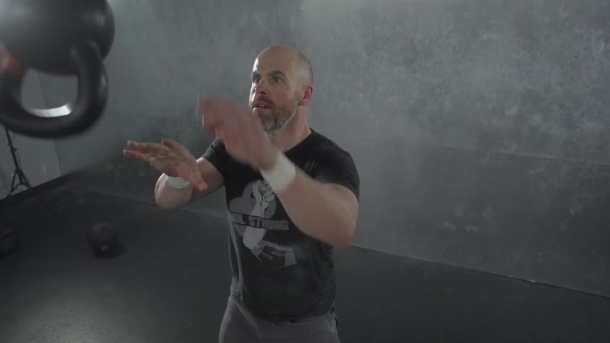 A man swinging and flipping a kettlebell