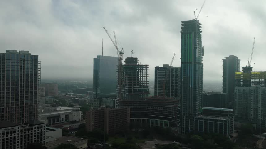 Skyscrapers under construction in a metropolis on a cloudy day