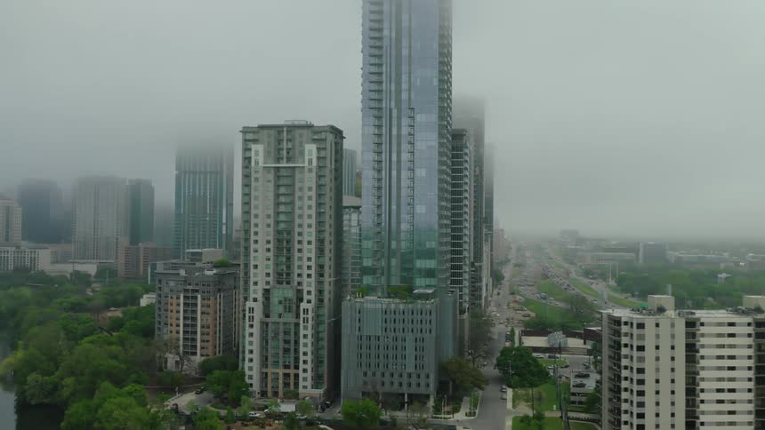 Cityscape with several tall buildings some of which are partially obscured by fog
