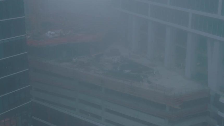 Skyscraper under construction seen on a foggy day