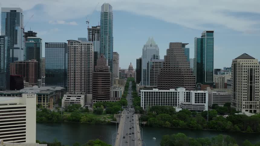 Aerial panorama of a viaduct above the sea giving access to a metropolis with skyscrapers