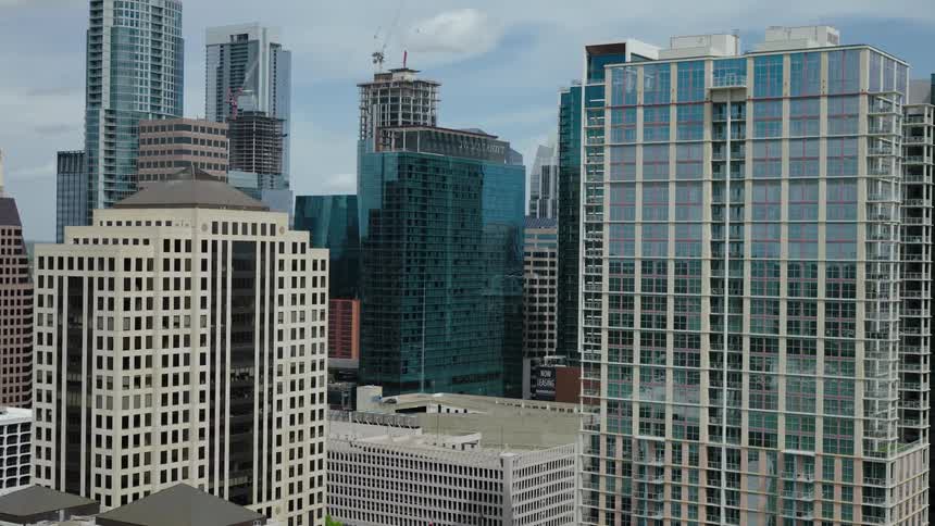 Cityscape with various highrise buildings some under construction against a cloudy sky