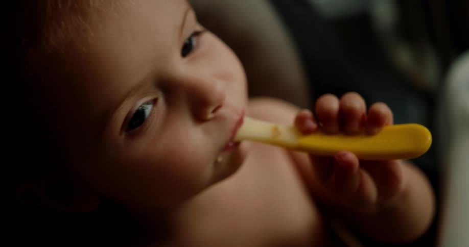 Baby licking a plastic spoon