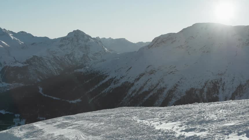 Mountain landscape with snow and the sun on the horizon