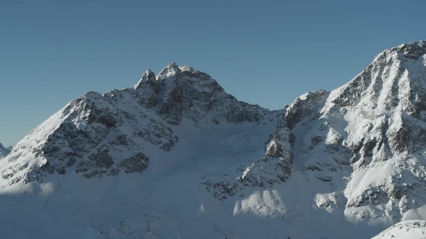 Snowy mountain scenery against a clear blue sky