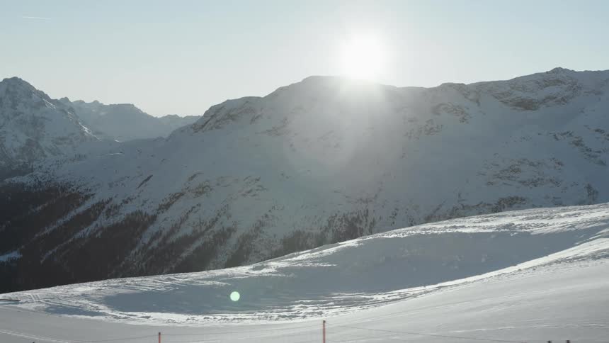 Landscape of snowy mountains and the sun on the horizon