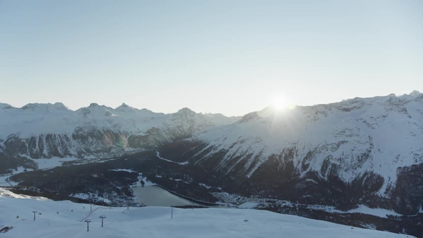The sun is peaking out at the top of the mountains