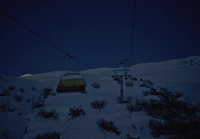 Moving view of cable cars on a snowy mountain at night