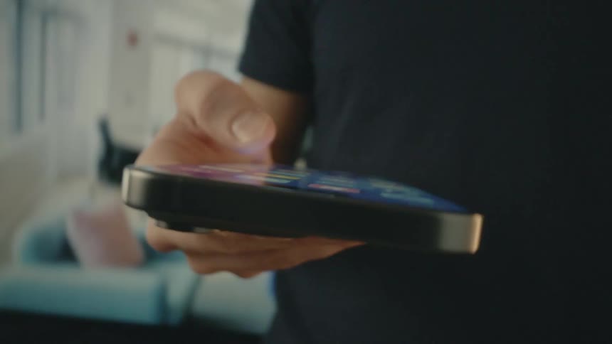 Spinning footage of a person scrolling through a smartphone in a brightly lit office