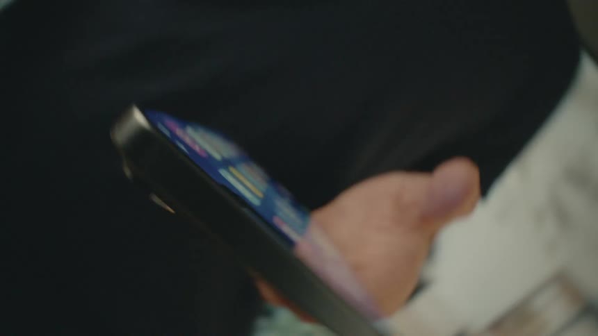 Spinning footage of a person scrolling through a smartphone in a brightly lit room