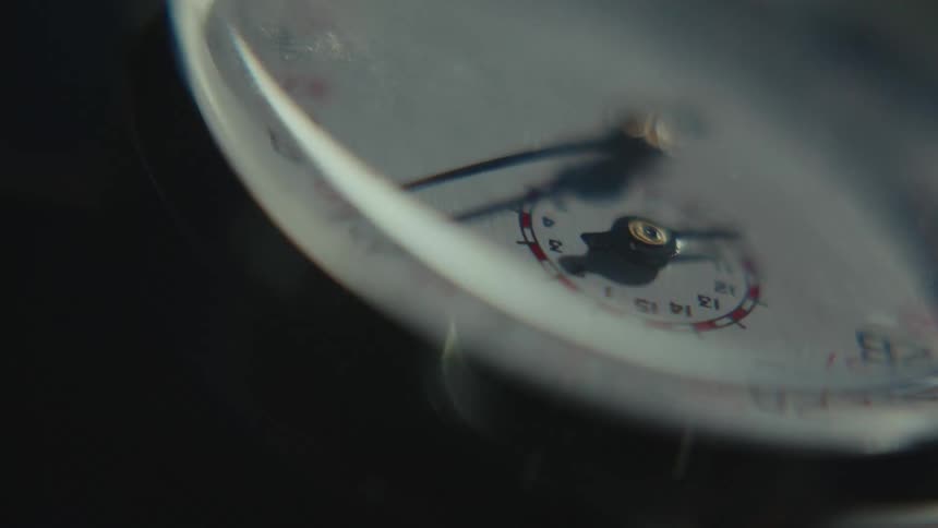 Light flickers and flashes onto an analog meter face